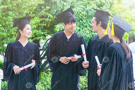 Group Of Portrait Happy Students In Graduation Gowns Holding Diplomas