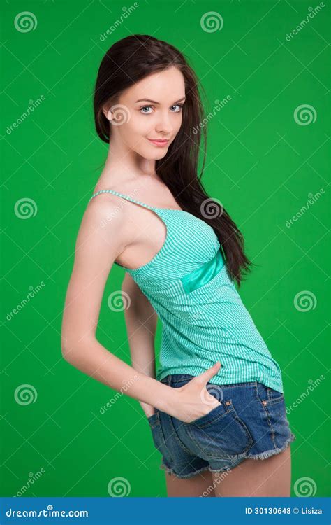 Portrait Of Beautiful Brunette Girl Wearing Shorts And Green Stock