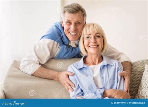 Lovely Mature Man Embracing Wife And Smiling To Camera Stock Image