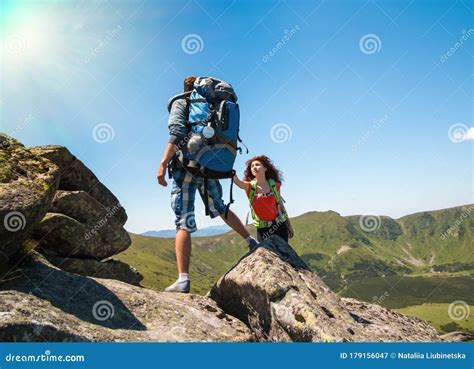 Close Up Of Loving Couple Hikers Climbing Up On The Peak Of Mountain