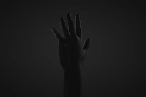 Premium Photo Raised Hand Dark Hand On A Dark Background