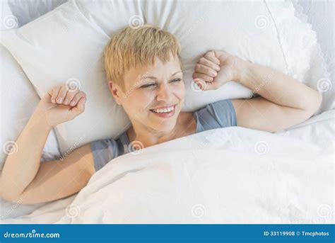 Mujer Feliz Que Despierta En Cama Foto De Archivo Imagen De Despierto