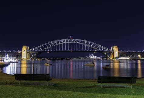 Night View Of Bridge With Boats Crossing Under During Nightime Sydney