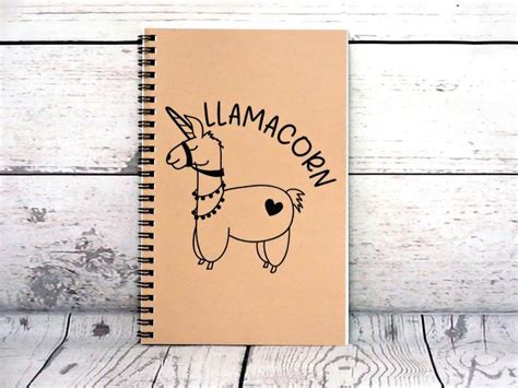 A Notebook With An Illustrated Llamacorn On It