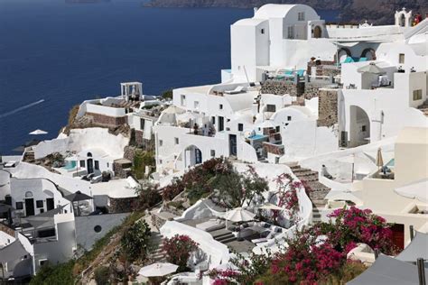 Whitewashed Houses With Terraces And Pools And A Beautiful View In Oia