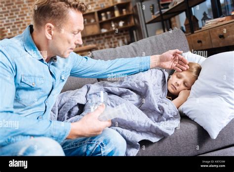 Worried Father Feeling The Forehead Of His Ill Son Stock Photo Alamy
