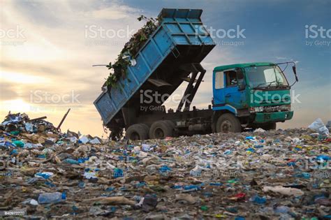Dump Truck Unloading The Waste On A Open Dumping Site Stock Photo