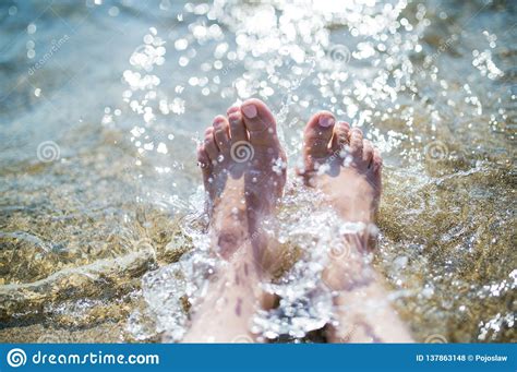 Close Up Of Female Feet In Water On Beach Summer Holiday Concept