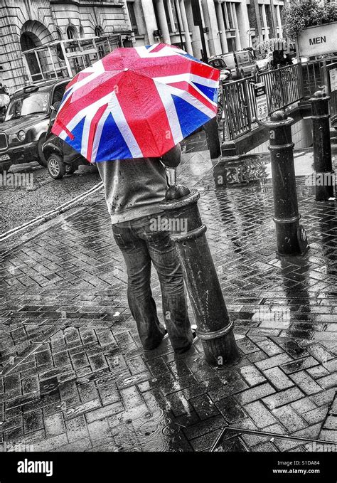 Black And White Selective Colour Photo Of A Man Standing In A Rain