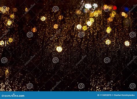 Bright Glowing Bokeh On Wet Glass Against Background Of The Nigh Stock