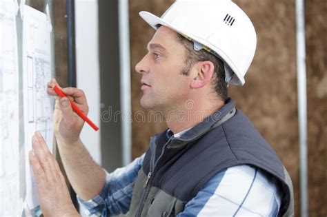 Architect Working On Blueprint Plans With Pencil Stock Photo Image Of