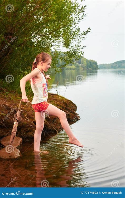 Mała Dziewczynka Z Parasolem W Chmurnym Dniu Blisko Jeziora Obraz Stock
