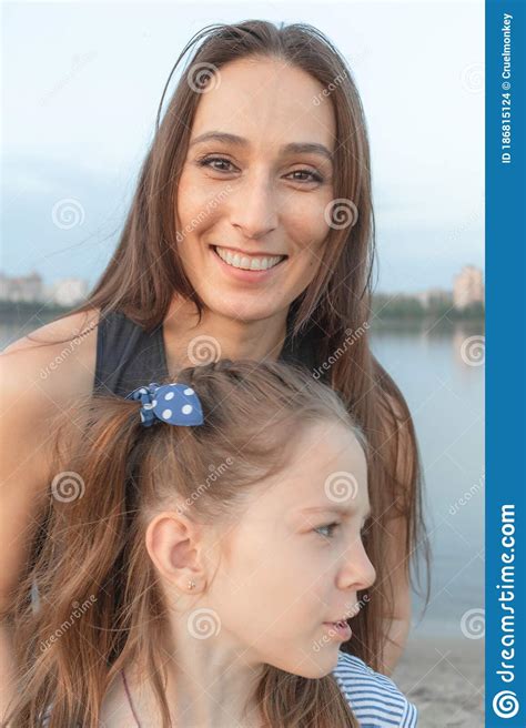 Mom And Daughter In Front Of The Camera Woman Smiles Beautifully And