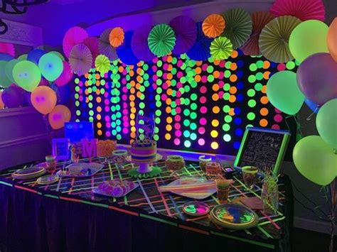 An Image Of A Party Setting With Neon Lights And Paper Umbrellas On The
