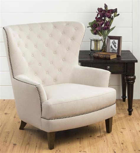 Classy White Tufted Wing Chair For Oversized Accent Chair With Wooden Legs On Wooden Floor Aside Wooden Side Table Beneath Brick Wall 
