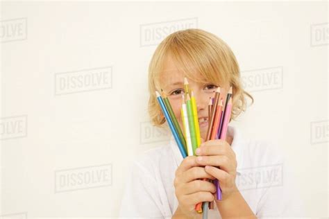 Schoolboy Holding Bunch Of Colouring Pencils Stock Photo Dissolve