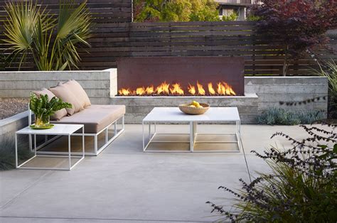 A Fire Pit In The Middle Of A Patio With Two Lounge Chairs And A Coffee