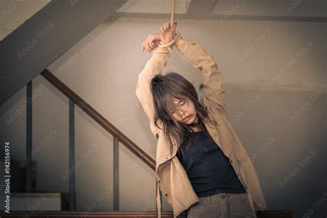 Female Hostage Are Tied Up With Ropes Hanging On Ladders Stock Photo