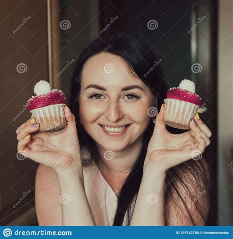 The Girl Holds Delicious Cupcakes With White Cream In Her Hands Decorated Balls With Coconut