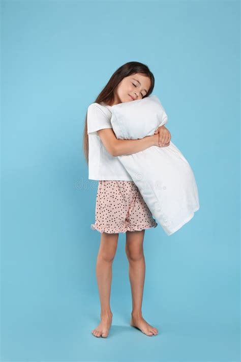 Cute Girl Wearing Pajamas With Pillow On Blue Background Stock Photo
