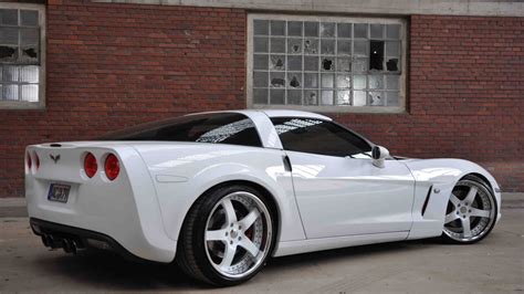A White Sports Car Parked In Front Of A Brick Building