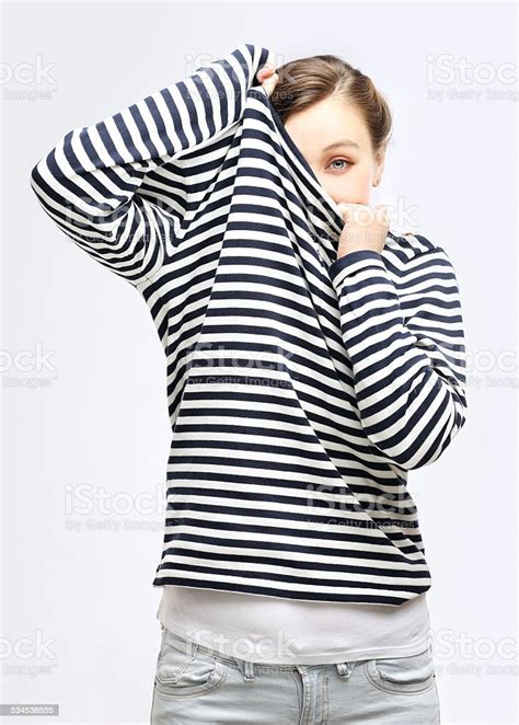 Girl Tucking Herself In Striped Sweater Stock Photo Download Image