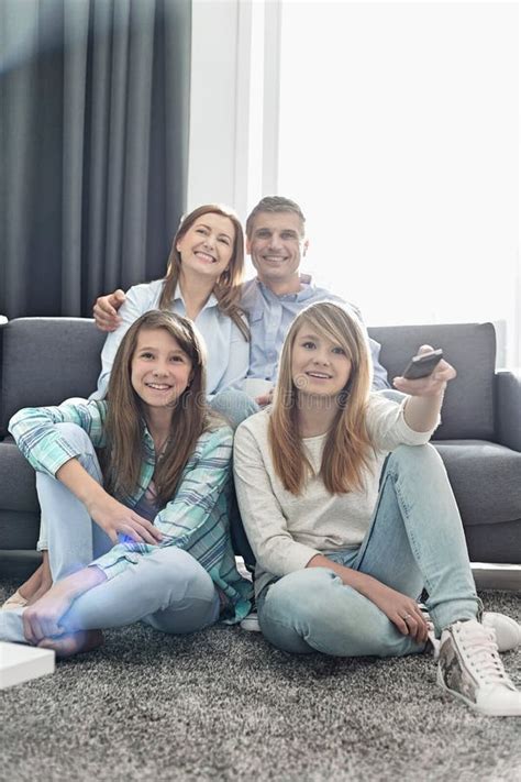 Familia De Cuatro Miembros Feliz Que Ve La Tv Junto En Casa Imagen De