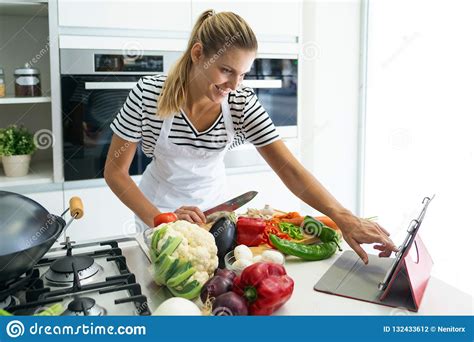Healthy Young Woman Cutting Fresh Vegetables And Using Digital Tablet ...