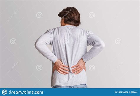 Body Ache And Kidneys Pain Man Presses His Hands To Back Stock Photo
