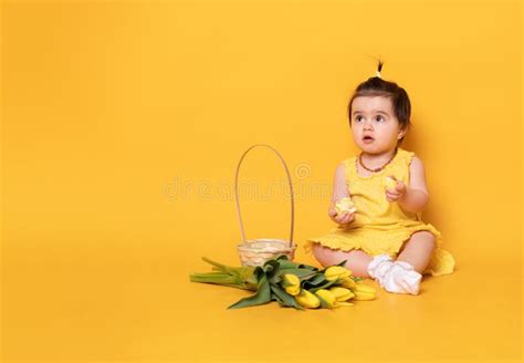Funny Cute Baby Girl In Yellow Dress With Tulips Basket With Colorful