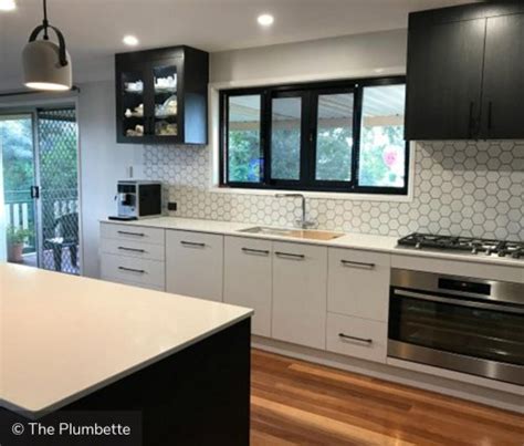 White cabinets are cooly contrasted with stainless accents. Two-Tone Kitchen Cabinets to Inspire Your Next Redesign
