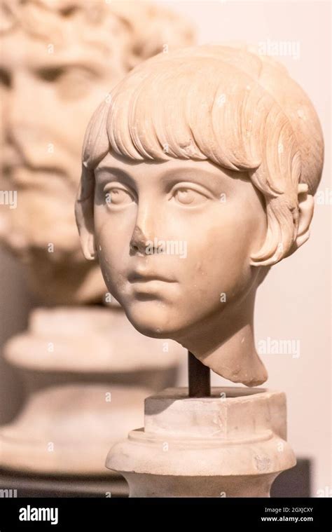 Close Up On Head Of Ancient Roman Statue In Ruins Representing A Little