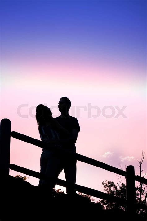 Silhouette Of An Affectionate Couple Romantically Kissing Each Other In