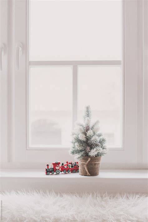 Small Snow Covered Christmas Tree Decoration And A Toy Train On A