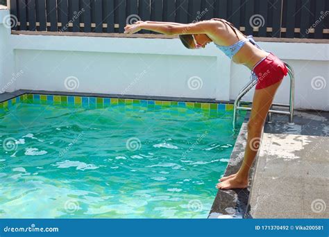 Slender Girl Jumps In The Pool In The Yard Diving Into Water From The