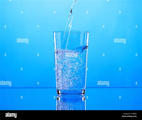 Pouring Water Into Glass On Blue Background Stock Photo Alamy