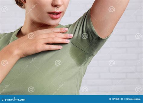 Young Woman With Sweat Stain On Her Clothes Against Brick Wall Using