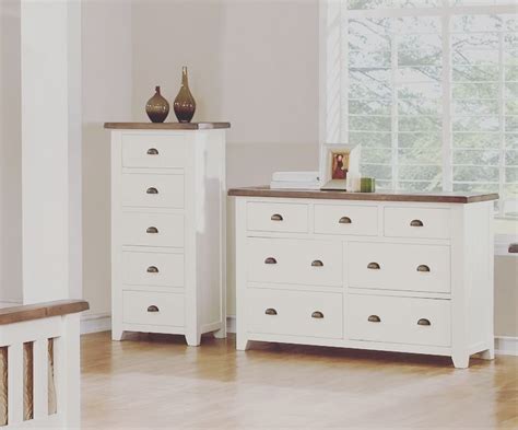 Two White Dressers With Drawers And Vases On Top Of Them In A Room