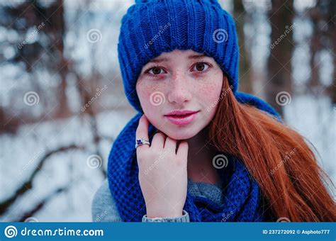 Portrait Of Young Red Hair Girl With Freckles Wearing At Blue Knitted