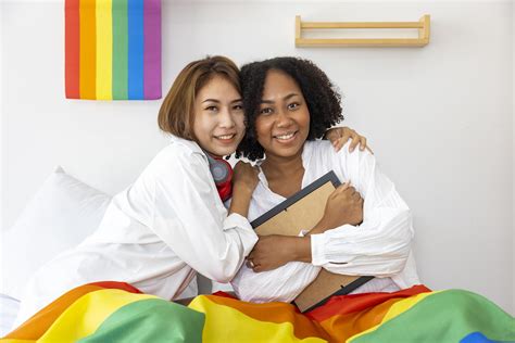Pareja De Matrimonios Del Mismo Sexo De Diferentes Razas Sosteniendo La Bandera Del Arco Iris