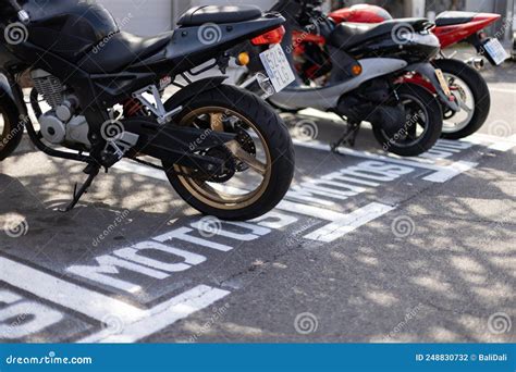 Motorbikes Parked On A Parking Lot Outside Sign On The Road Stock