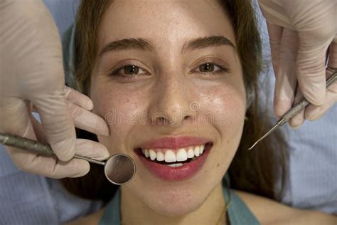 Professional Female Dentist Treating Female Patient S Teeth In A Dental