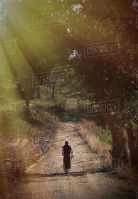 Person Walking Down Country Road In Sunlight Stock Photo Dissolve