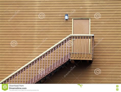 Wooden Stairs Leading To A Door In The Middle Of A Wall