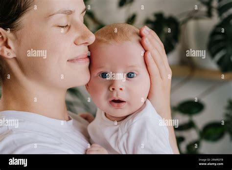 Caring mom embrace caress lull small toddler son. Close-up portrait of
