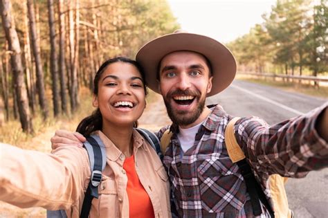 casal sorridente tirando uma selfie enquanto viaja foto grátis