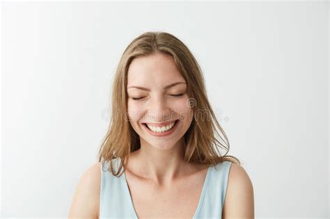beautiful sincere happy cheerful girl smiling laughing with closed eyes over white background