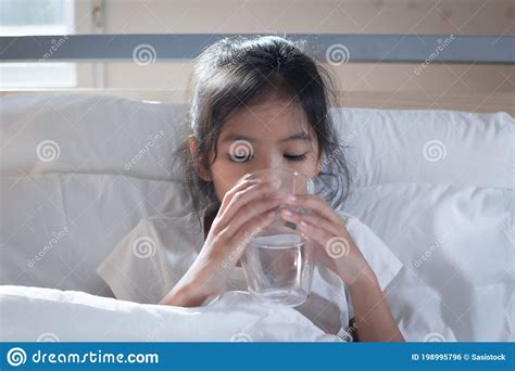 Sick Asian Child Girl Is Drinking Water From A Glass After Eat Medicine