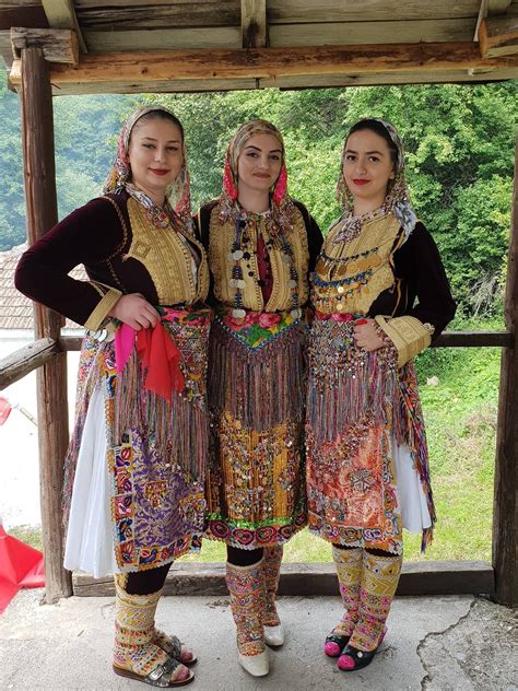 three women dressed in colorful clothing standing next to each other on