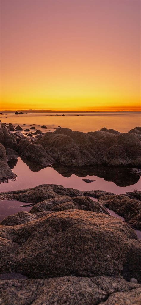 Rocky Shore During Sunset With Orange Sky Iphone X Wallpapers Free Download